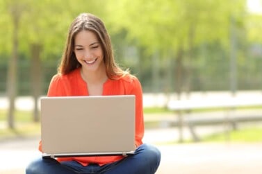online jobs for teens happy girl taking online surveys on her laptop because she needs money now