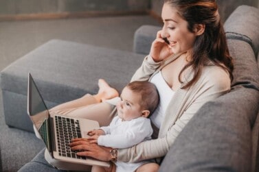 Mom working from home with her baby son and laptop. Stay-at-home mom jobs.